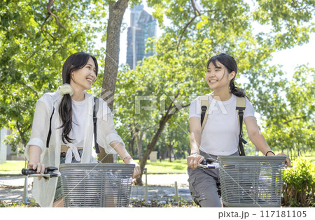 Teenage girls with backpacks on bicycles going to school Teenage girls with backpacks on bicycles going to school 117181105