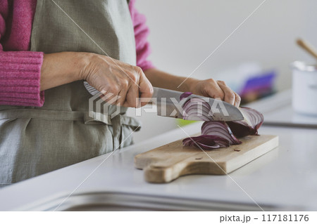 玉ねぎを切るシニア女性の手元 117181176