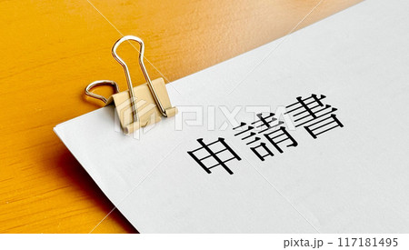 クリップで留めた用紙に申請書の文字 117181495