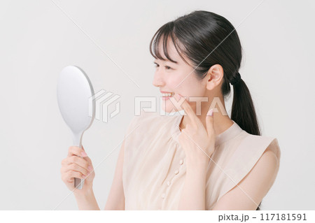 鏡を見て微笑む若い女性 117181591
