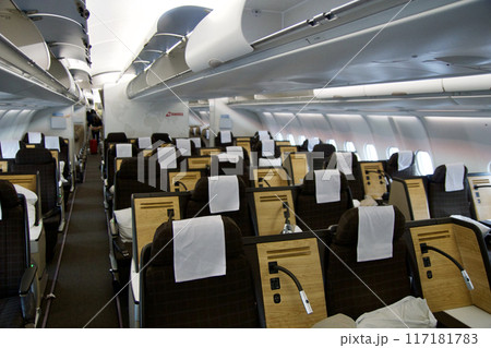 ZURICH, SWITZERLAND - JUNE 22, 2019: Empty cabin with business class seats with wood applications and brown fabric in a long-haul aircraft on the flight from Dubai to Zurich 117181783
