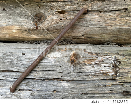 Old wooden log wall. Logs are connected by a metal clamp. Old wooden log wall. Logs are connected by a metal clamp. 117182875