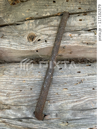 Old wooden log wall. Logs are connected by a metal clamp. 117182879