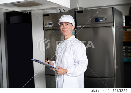 厨房で検査をする衛生服を着たアジア人男性 117183281