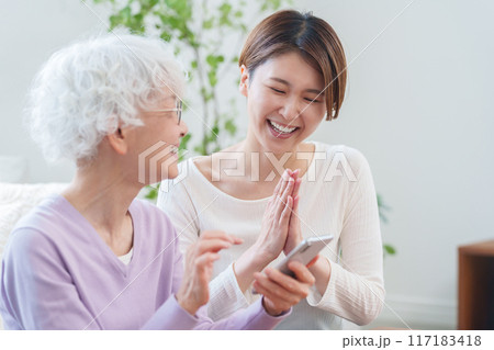 高齢者の母親にスマホを教える娘（家族・ファミリー） 117183418