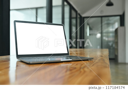Laptop with blank screen on wood table in modern office. Close up shot ...