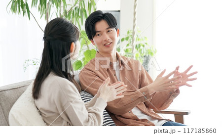 リビングで語り合うカップル 117185860
