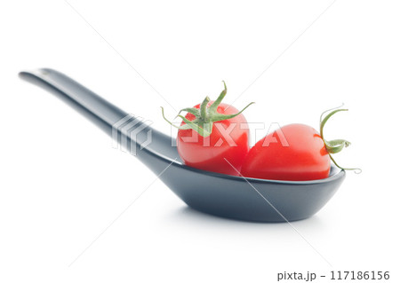 Red cherry tomatoes in ceramic spoon isolated on white background. Red cherry tomatoes in ceramic spoon isolated on white background. 117186156