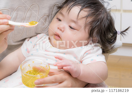 【離乳食を食べる髪を結んだ赤ちゃん】 【離乳食を食べる髪を結んだ赤ちゃん】 117186219