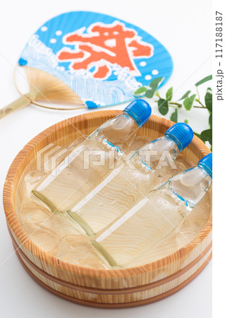 水と氷の入った桶で冷やされるラムネとお祭りの団扇 117188187