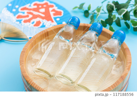 水と氷の入った桶で冷やされるラムネとお祭りの団扇 117188556
