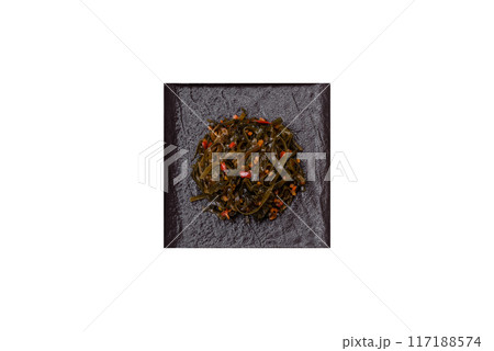 Delicious marinated seaweed with paprika, spices and salt on a dark concrete background 117188574