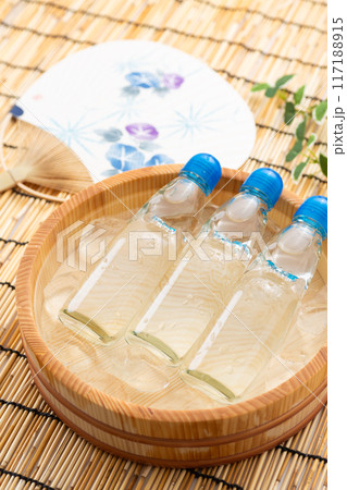 水と氷の入った桶で冷やされるラムネとお祭りの団扇 117188915