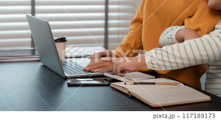 Mother and Daughter Bonding Over Laptop at Home, Sharing Quality Time and Learning Together 117189173