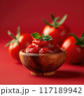 Promotional poster of tomato paste in a small wooden bowl, foreground, red background 117189942