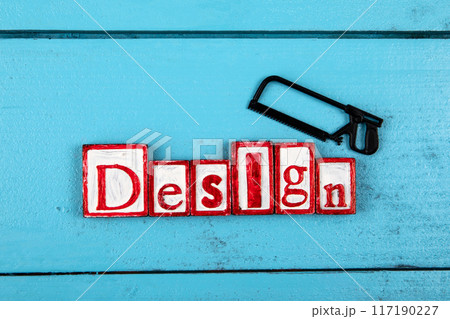 DESIGN. Miniature saw on a blue wooden background. construction and carpentry concept DESIGN. Miniature saw on a blue wooden background. construction and carpentry concept 117190227