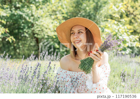 Young beautiful woman picking lavender flowers. 117190536