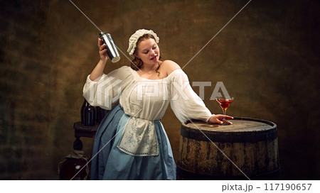 Jovial woman in traditional attire shakes cocktail mixer, preparing festive drink for celebration, with barrel and glass ready for toasting. Jovial woman in traditional attire shakes cocktail mixer, preparing festive drink for celebration, with barrel and glass ready for toasting. 117190657
