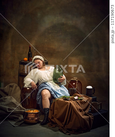 Woman in traditional attire relaxes with jug in hand, surrounded by rustic items like barrels, and simple food in tranquil, homely atmosphere. Woman in traditional attire relaxes with jug in hand, surrounded by rustic items like barrels, and simple food in tranquil, homely atmosphere. 117190673
