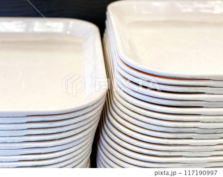食堂に置いてある重ねたたくさんのトレー 117190997