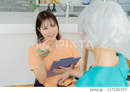 車椅子に乗った女性をサポートする介護士 車椅子に乗った女性をサポートする介護士 117192337
