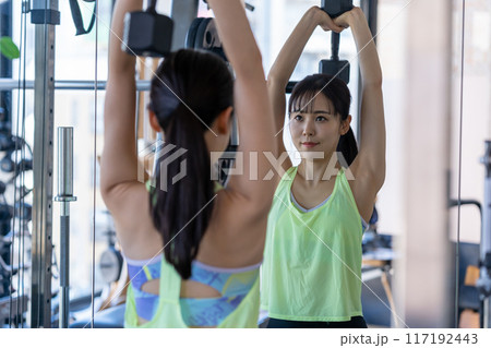 スポーツジムでトレーニングする若い女性 117192443