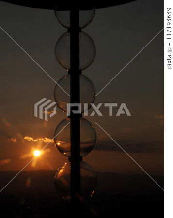 ガラス製の電気スタンドと夕陽（あかね雲と六甲山に沈んで行く夕日） 117193639