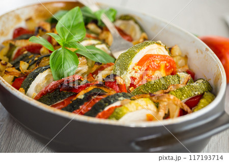 prepared baked zucchini and tomatoes in circles in a ceramic form, vegetable snack prepared baked zucchini and tomatoes in circles in a ceramic form, vegetable snack 117193714