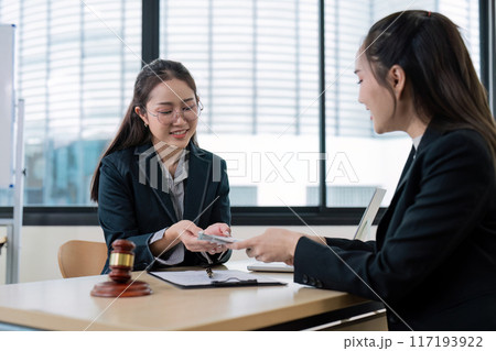 Professional Female Lawyers Discussing Legal Documents in Modern Office Setting 117193922
