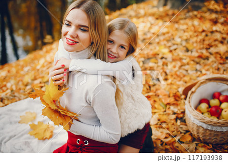 Fashionable mother with daughter. Family in a autumn park. 117193938
