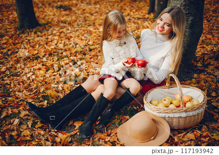 Fashionable mother with daughter. Family in a autumn park. Fashionable mother with daughter. Family in a autumn park. 117193942