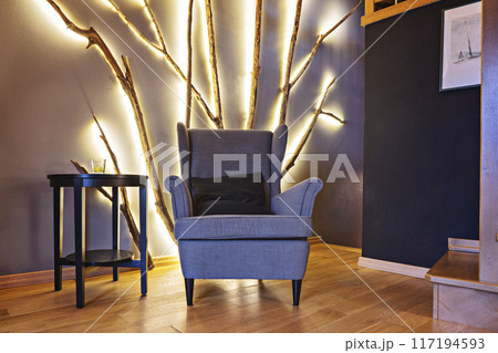 Vintage armchair in living room with homemade tree branch led-lamp on wall, DIY interior detail Vintage armchair in living room with homemade tree branch led-lamp on wall, DIY interior detail 117194593