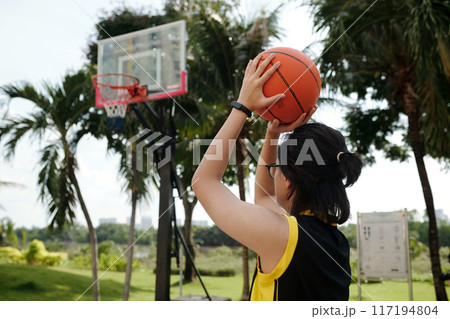 Playing Basketball Outdoors in Tropical Setting 117194804