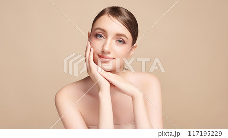 Beautiful young woman with clean fresh skin on beige background, Face care, Facial treatment, Cosmetology, beauty and spa, women portrait. Beautiful young woman with clean fresh skin on beige background, Face care, Facial treatment, Cosmetology, beauty and spa, women portrait. 117195229