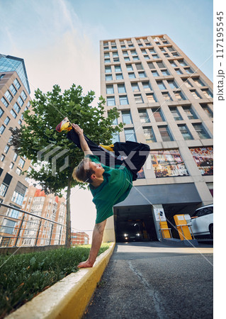 Parkrun devotee jumps high against modern buildings, reflecting excitement and vitality of parkrun events. Fashion and modern lifestyle. 117195545