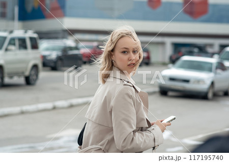 Young beautiful blonde turned around while talking on the phone in the city. Young beautiful blonde turned around while talking on the phone in the city. 117195740