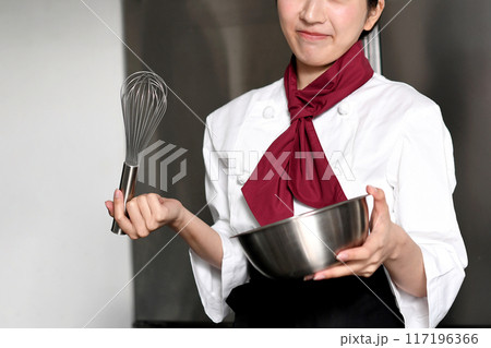 厨房で悩む若いアジア人の女性の料理人 厨房で悩む若いアジア人の女性の料理人 117196366