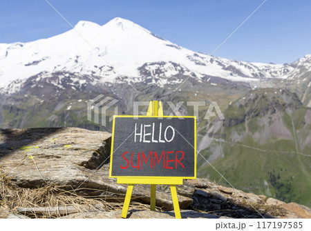 Hello summer symbol. Concept words Hello summer on beautiful yellow blackboard. Beautiful mountain Elbrus background. Business lifestyle Hello summer concept. Copy space. 117197585