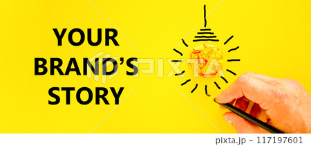 Branding and your brand story symbol. Concept words Your brands story on beautiful yellow paper. Beautiful yellow background. Businessman hand. Business branding your brand story concept. Copy space. 117197601