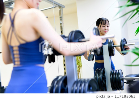 ジムで体を鍛える女性の背中 バーベルプレート ウェイト選び 筋トレ女子 ワークアウト ジムで体を鍛える女性の背中 バーベルプレート ウェイト選び 筋トレ女子 ワークアウト 117198063