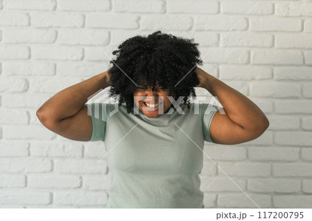 Angry millennial african american woman screaming on brick background. Bad aggressive emotions and premenstrual syndrome or pms concept Angry millennial african american woman screaming on brick background. Bad aggressive emotions and premenstrual syndrome or pms concept 117200795