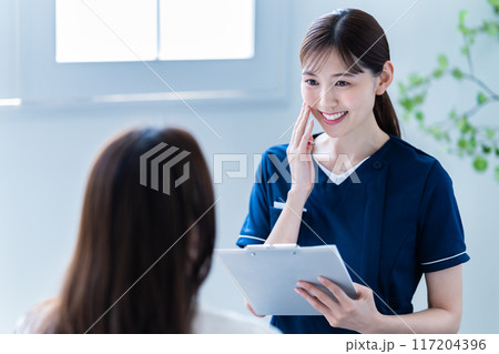 美容クリニックでカウンセリングをする女性スタッフ 美容クリニックでカウンセリングをする女性スタッフ 117204396