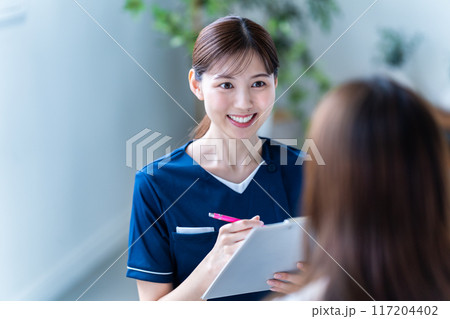 美容クリニックでカウンセリングをする女性スタッフ 117204402