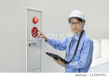 火災報知器の点検をする作業服の男性　カメラ目線　ビルメンテナンス　イメージ 117204741