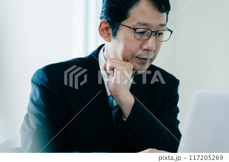 書類を見て悩むビジネスマン 書類を見て悩むビジネスマン 117205269