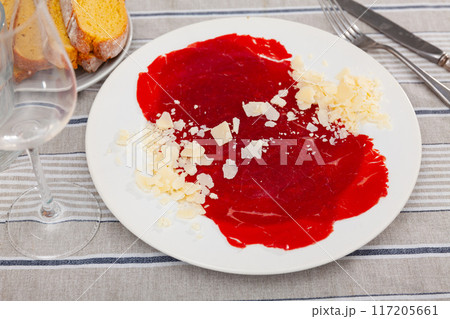 Carpaccio and cheese served on plate. Dish made of raw beef meat closeup Carpaccio and cheese served on plate. Dish made of raw beef meat closeup 117205661
