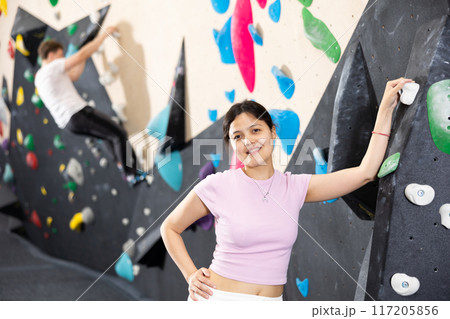 Young asian woman posing against climbing wall Young asian woman posing against climbing wall 117205856