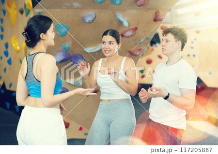 Sports women and man are actively discussing the successes and mistakes of other athletes on mountaineering simulator 117205887