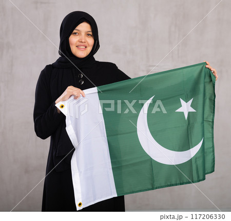Young woman in hijab posing with Pakistan flag 117206330