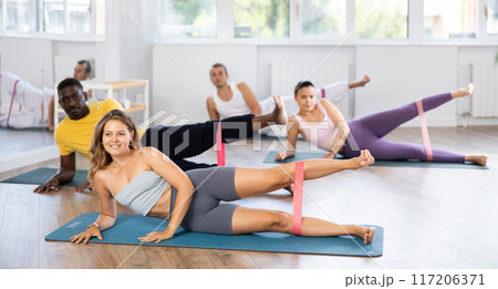 Girl using resistance loop during group pilates workout 117206371